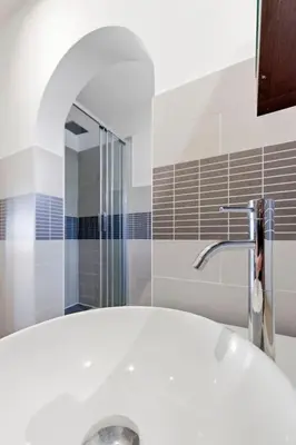 a bathroom with a white sink and a shower at Cozy 1 bedroom flat,free parking, close to center in Cannes