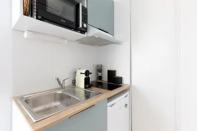 a kitchen with a sink and a microwave at The Green Sun YourHostHelper in Cannes
