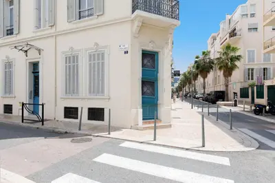 a street with a building with a blue door at The Green Sun YourHostHelper in Cannes