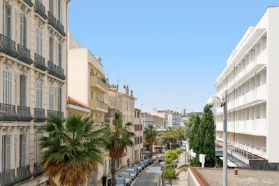 a city street with buildings and a palm tree at The Green Sun YourHostHelper in Cannes
