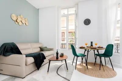 a living room with a couch and a table and chairs at The Green Sun YourHostHelper in Cannes