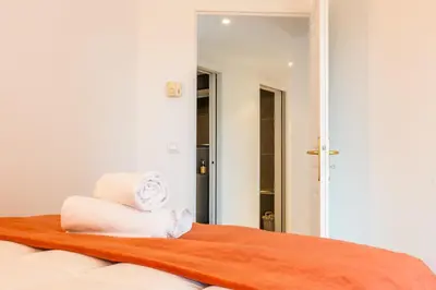a room with a bed with towels and a mirror at 3-Room Luxury Apartment with Pool and Sea View Steps from the Beach in Cannes
