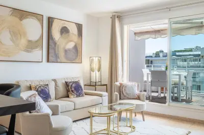 a living room with a couch and a table at 3-Room Luxury Apartment with Pool and Sea View Steps from the Beach in Cannes