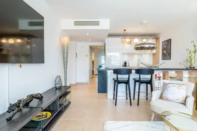 a kitchen and living room with a table and chairs at 3-Room Luxury Apartment with Pool and Sea View Steps from the Beach in Cannes