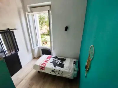 a room with a bed in a room with a window at CANNES t4 bourgeois 790M de la plage, Palais et Croisette in Cannes