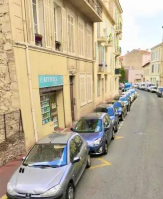 a row of cars parked on the side of a street at CANNES t4 bourgeois 790M de la plage, Palais et Croisette in Cannes