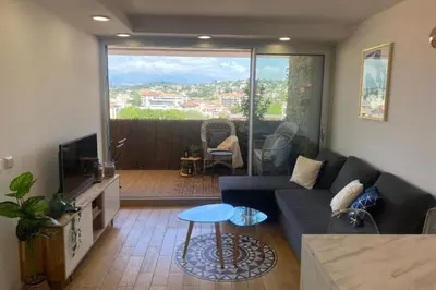 a living room with a blue couch and a television at Vue panoramique, plage à 100m in Cannes