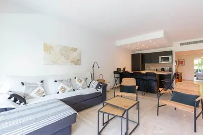 a living room with a couch and chairs and a kitchen at WE CANNES ! Exceptional 4 rooms apartment Cannes Center swimming pool in Cannes