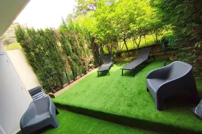 two benches sitting on a grassy yard with trees at WE CANNES ! Exceptional 4 rooms apartment Cannes Center swimming pool in Cannes