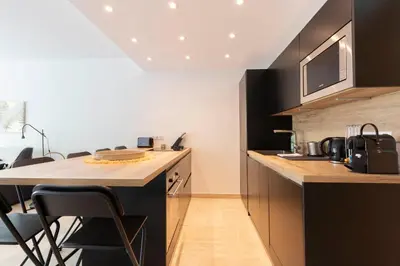 a kitchen with a counter and a table and chairs at WE CANNES ! Exceptional 4 rooms apartment Cannes Center swimming pool in Cannes