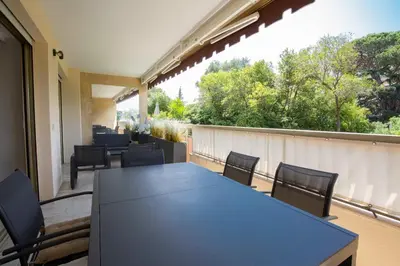 a black table and chairs on a balcony at WE CANNES ! Exceptional 4 rooms apartment Cannes Center swimming pool in Cannes