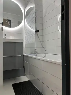a white bathroom with a tub and a sink at Appartement vue sur mer in Cannes