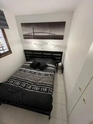 a bedroom with a bed with a bridge above it at Appartement vue sur mer in Cannes