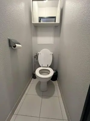 a small bathroom with a white toilet in a stall at Appartement vue sur mer in Cannes