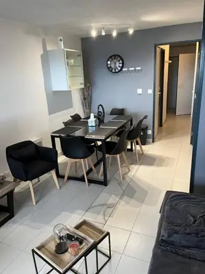 a living room with a dining table and chairs at Appartement vue sur mer in Cannes