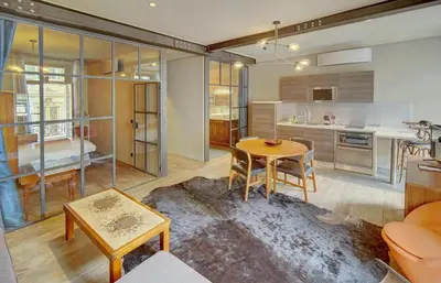 a living room with a table and a kitchen at Red & Bleue YourHostHelper in Cannes