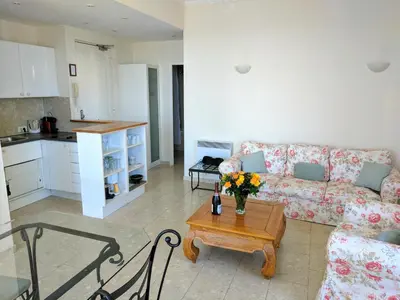 a living room with a couch and a table with flowers on it at Citilet Louis Blanc 1,2,3 - Three gorgeous, open-plan apartments in Cannes