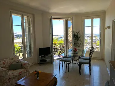 a living room with a table and chairs and windows at Citilet Louis Blanc 1,2,3 - Three gorgeous, open-plan apartments in Cannes