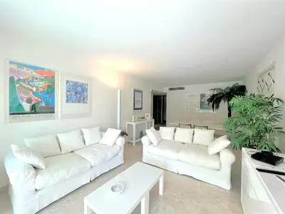 a white living room with white couches and a potted plant at Ambre d' Or apartment by Welcome to Cannes in Cannes