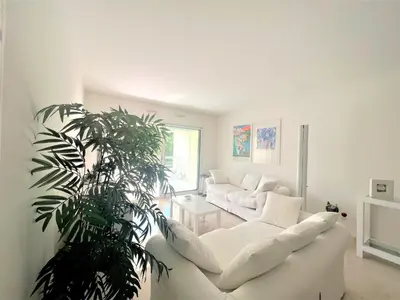 a living room with a white couch and a plant at Ambre d' Or apartment by Welcome to Cannes in Cannes