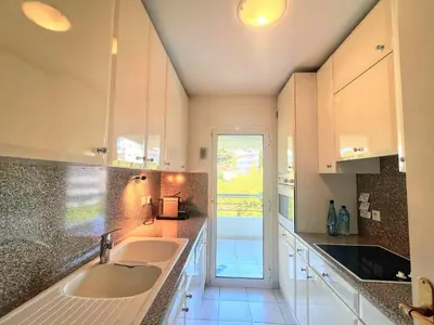 a white kitchen with two sinks and a doorway at Ambre d' Or apartment by Welcome to Cannes in Cannes