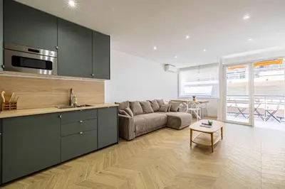 a kitchen and living room with a couch and a table at Cozy renovated apartment - close to Martinez Hotel in Cannes