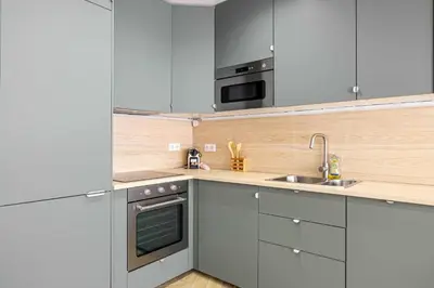 a kitchen with white cabinets and a sink at Cozy renovated apartment - close to Martinez Hotel in Cannes