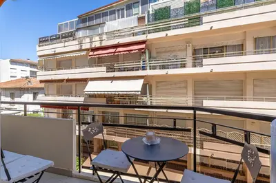 a balcony with a table and chairs and a building at Cozy renovated apartment - close to Martinez Hotel in Cannes