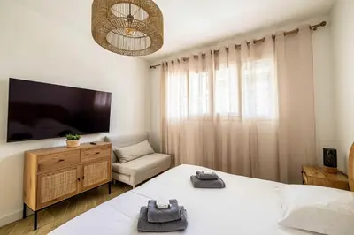 a bedroom with a bed and a tv and a chair at Cozy renovated apartment - close to Martinez Hotel in Cannes