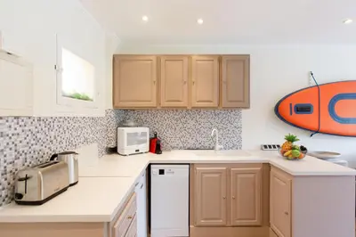 a kitchen with a sink and a microwave at Les 3 Palmiers YourHostHelper in Cannes