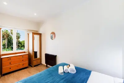 a bedroom with a bed with two towels and a tv at Les 3 Palmiers YourHostHelper in Cannes
