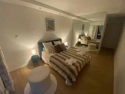 a bedroom with a bed and a table and a mirror at Mathéo in Cannes