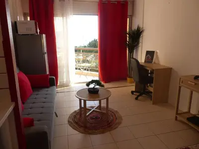 a living room with a couch and a table in front of a window at magnifique APPARTEMENT vue mer Parking Piscine Plage Climatisé in Cannes