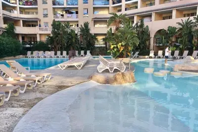 a swimming pool with lounge chairs and a hotel at magnifique APPARTEMENT vue mer Parking Piscine Plage Climatisé in Cannes