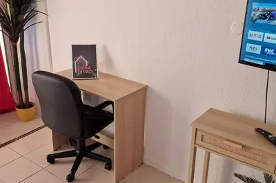 a desk with a chair next to a computer monitor at magnifique APPARTEMENT vue mer Parking Piscine Plage Climatisé in Cannes