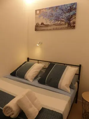 a bed with two pillows and a painting on the wall at magnifique APPARTEMENT vue mer Parking Piscine Plage Climatisé in Cannes