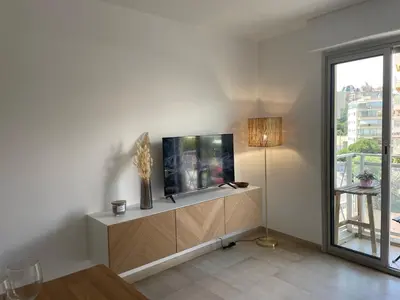 a living room with a fish tank on a cabinet at Studio Balcon Centre Plage in Cannes