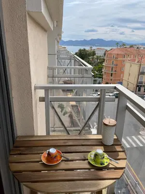 a balcony with two cups and saucers on a table at Studio Balcon Centre Plage in Cannes