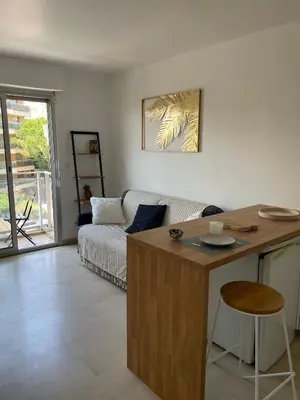 a living room with a couch and a table at Studio Balcon Centre Plage in Cannes