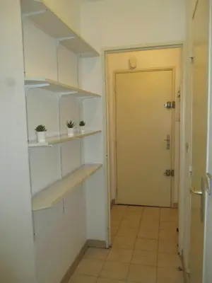 a hallway with shelves and a door to a room at Studio au calme à 5mn de la mer et de toutes attractions de la ville in Cannes