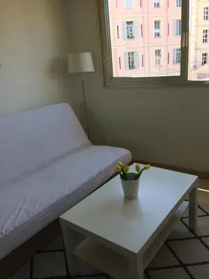 a room with a bed and a table and a window at Studio au calme à 5mn de la mer et de toutes attractions de la ville in Cannes