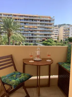 a table and two glasses of wine on a balcony at Appartement Mimosa Croisette in Cannes