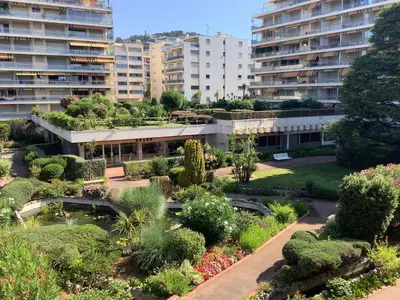 an apartment complex with a garden and buildings at Appartement Mimosa Croisette in Cannes