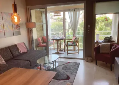 a living room with a couch and a table at Appartement Mimosa Croisette in Cannes