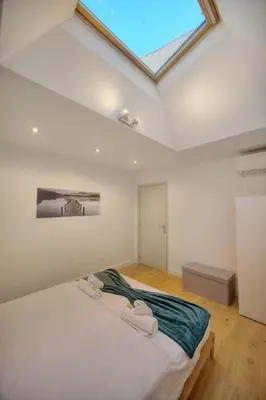 a bedroom with a large bed with a skylight at IMMOGROOM - Heart of the Suquet - City center - Modern in Cannes