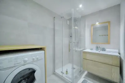 a bathroom with a washing machine and a sink at IMMOGROOM - Heart of the Suquet - City center - Modern in Cannes