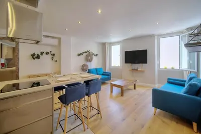 a kitchen and a living room with blue chairs at IMMOGROOM - Heart of the Suquet - City center - Modern in Cannes