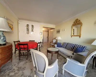 a living room with a couch and a table and chairs at LA PRESQU'ILE T2 PALM BEACH MOURE ROUGE in Cannes