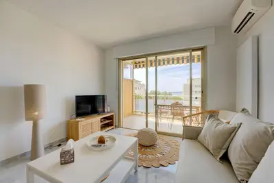 a living room with a white couch and a tv at Cannes Californie Beautiful Apt with Sea View in Cannes