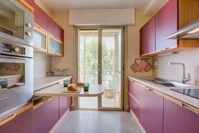 a kitchen with purple cabinets and a table with food on it at Cannes Californie Beautiful Apt with Sea View in Cannes